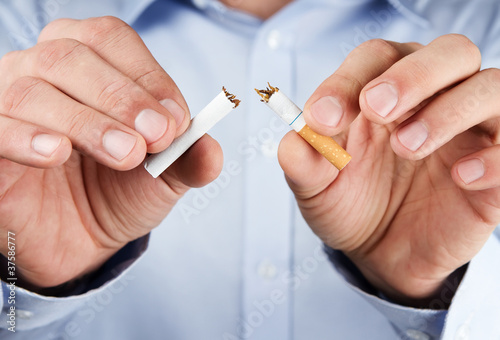 Photo: Quit smoking, human hands breaking up cigarette Quit smoking, human hands breaking up cigarette
