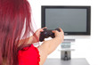 Foto: Frau spielt Videogame vor Fernseher Frau spielt Videogame vor Fernseher