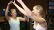 Fitness trainer helping woman in gym