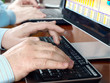 Hands typing on computer keyboard