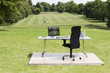 Office desk and chair outdoors in field