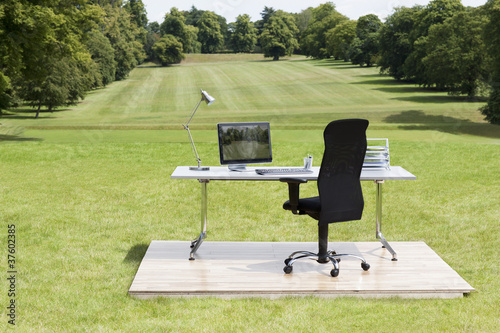 Photo: Office desk and chair outdoors in field Office desk and chair outdoors in field