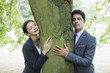 Business people hugging tree