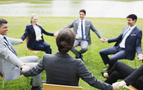 Photo: Business people holding hands in circle outdoors Business people holding hands in circle outdoors