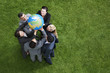 Business people lifting globe together outdoors