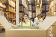 Woman in warehouse closing cardboard box