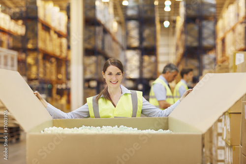 Foto: Woman in warehouse closing cardboard box Woman in warehouse closing cardboard box