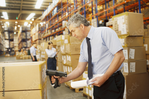Foto: Businessman scanning shipping box in warehouse Businessman scanning shipping box in warehouse