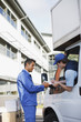Foto: Deliveryman signing clipboard Deliveryman signing clipboard