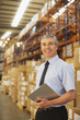 Businessman with clipboard in warehouse