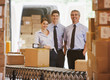Foto: Business people standing with boxes in shipping area Business people standing with boxes in shipping area