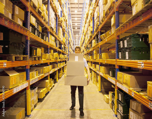 Foto: Worker carrying boxes in warehouse Worker carrying boxes in warehouse