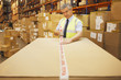 Worker taping box in warehouse