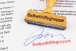 Holzstempel auf Dokument: Selbsthilfegruppe
