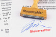 Holzstempel auf Dokument: Steuerzahler