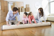 Family unrolling carpet together in new home