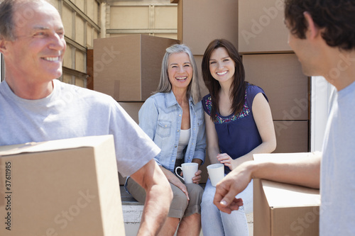 Photo: Woman drinking coffee on back of moving van Woman drinking coffee on back of moving van