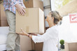 Husband handing box to wife from moving van