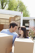 Couple unloading boxes from moving van
