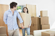 Couple carrying moving boxes into new home