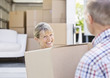 Couple unloading boxes from moving van