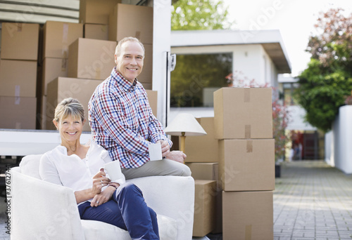 Photo: Couple sitting with moving and boxes Couple sitting with moving and boxes