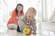 Foto: Mother watching baby playing with ball Mother watching baby playing with ball