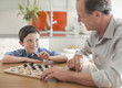 Grandfather and grandson playing checkers together