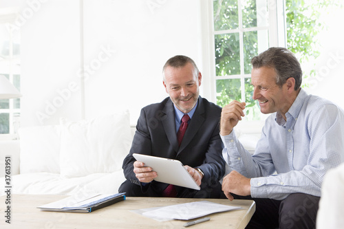 Foto: Financial advisor showing digital tablet to customer Financial advisor showing digital tablet to customer
