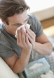 Sick man blowing his nose