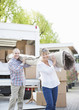 Couple carrying carpet from moving van