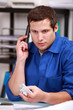 Foto: Electrician checking a part over the phone Electrician checking a part over the phone
