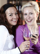 Foto: Pretty girlfriends with a glass of wine enjoy their evening Pretty girlfriends with a glass of wine enjoy their evening