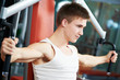 positive man at chest exercises machine