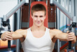 positive man at chest exercises machine
