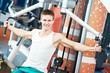 positive man at chest exercises machine