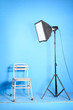 Studio flash with softbox and old chair over the blue background
