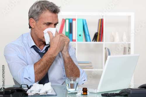 Photo: Office worker suffering from a cold Office worker suffering from a cold