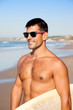 Handsome muscular surfer with surf board