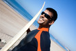 Surfer wearing a wetsuit with surf board.