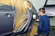 Worker painting a car.