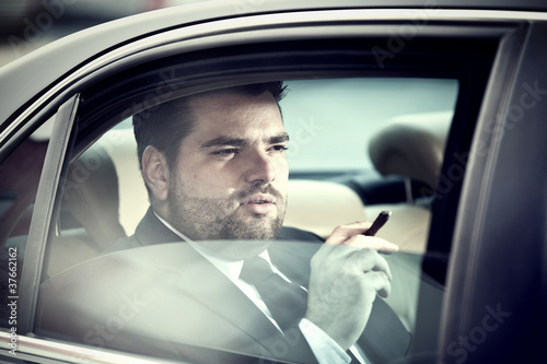 Photo: Man in the back seat of a car smoking Man in the back seat of a car smoking