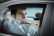 Photo: Man in the back seat of a car smoking Man in the back seat of a car smoking