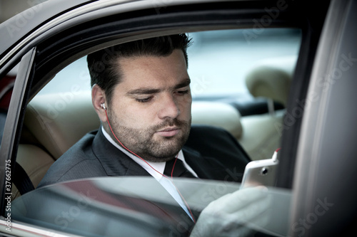 Photo: Businessman listening to music on his phone Businessman listening to music on his phone