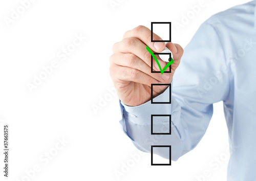 Photo: Human hand checking the checklist boxes Human hand checking the checklist boxes