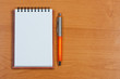 Notebook and ballpen on table.