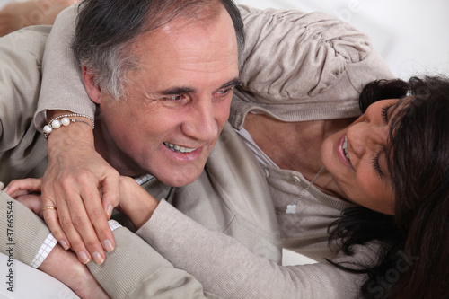 Foto: A middle age couple fooling around in bed. A middle age couple fooling around in bed.