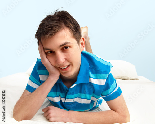 Photo: Smiling boy resting on bed Smiling boy resting on bed
