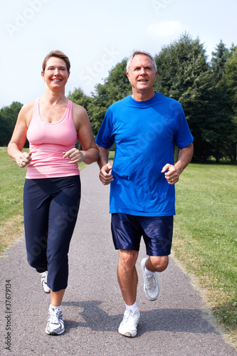 Photo: Senior couple jogging in park. Senior couple jogging in park.