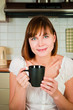 young  woman, enjoying a cup of coffee in her home.